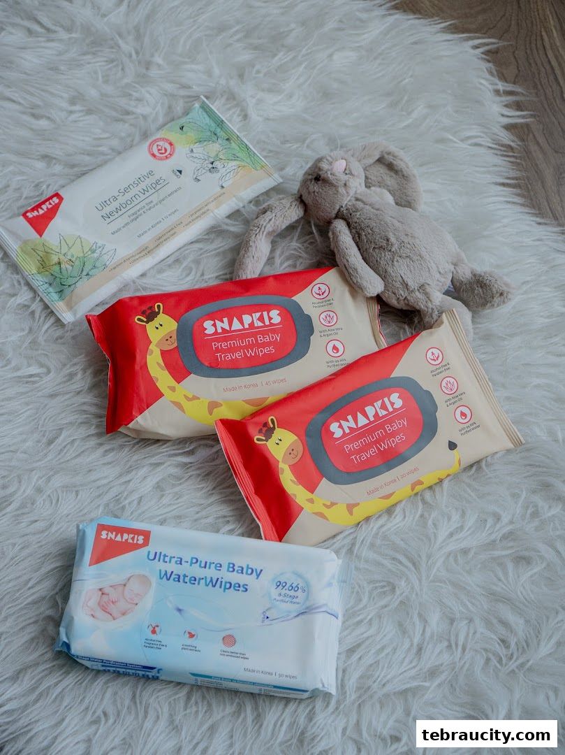 A collection of baby wipes and a plush bunny toy arranged on a fluffy white rug.