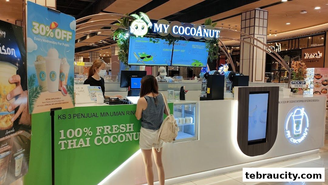 A customer orders at the My Cocoanut beverage stall, which offers fresh Thai coconut drinks.
