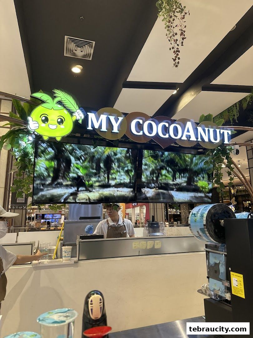 A shop counter with a "My Cocoanut" sign and a staff member preparing drinks.
