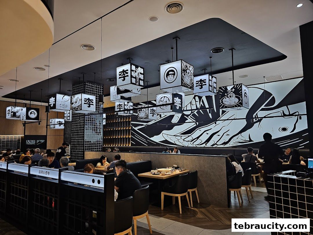 Interior of a modern restaurant with black and white decor, featuring hanging cube lights and a large mural.