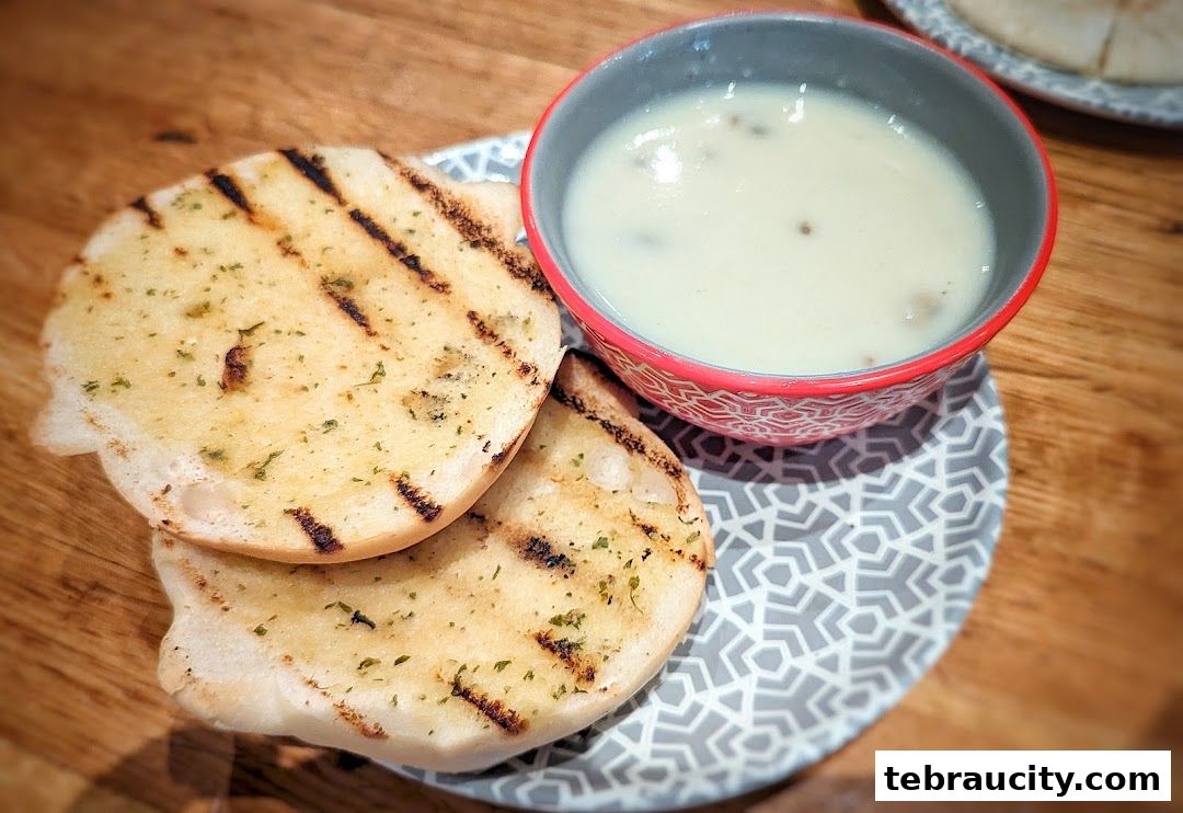 Grilled garlic bread served with a bowl of creamy mushroom soup.