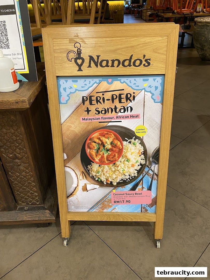 A Nando's A-frame sign advertising a Peri-Peri + Santan Coconut Saucy Bowl.