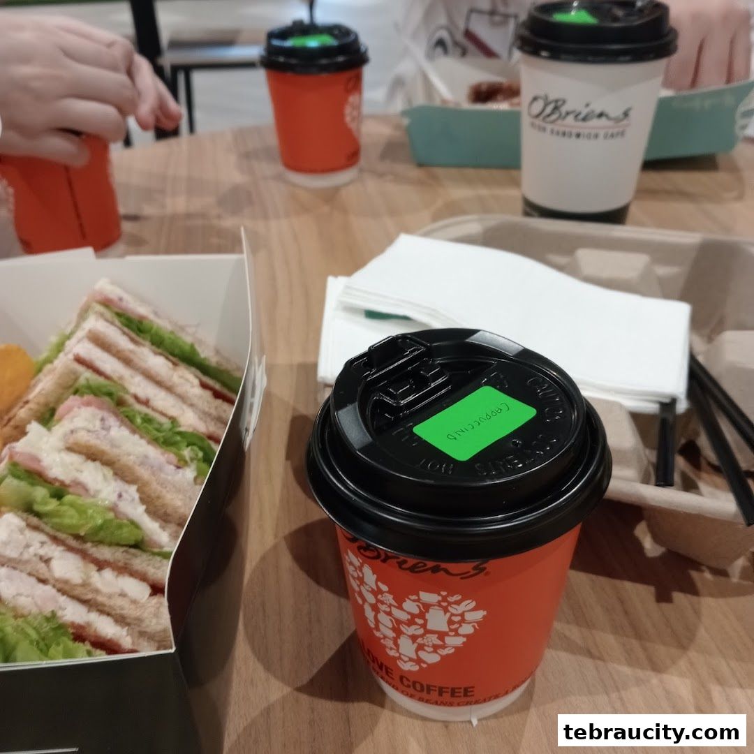 A sandwich and coffee from O'Briens Irish Sandwich Cafe on a wooden table.