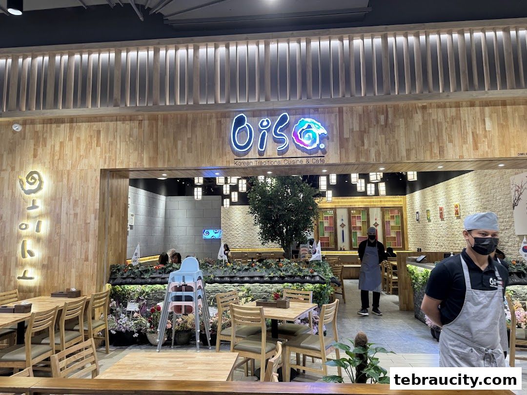 The entrance of Oiso Korean Restaurant with wooden decor and staff members.