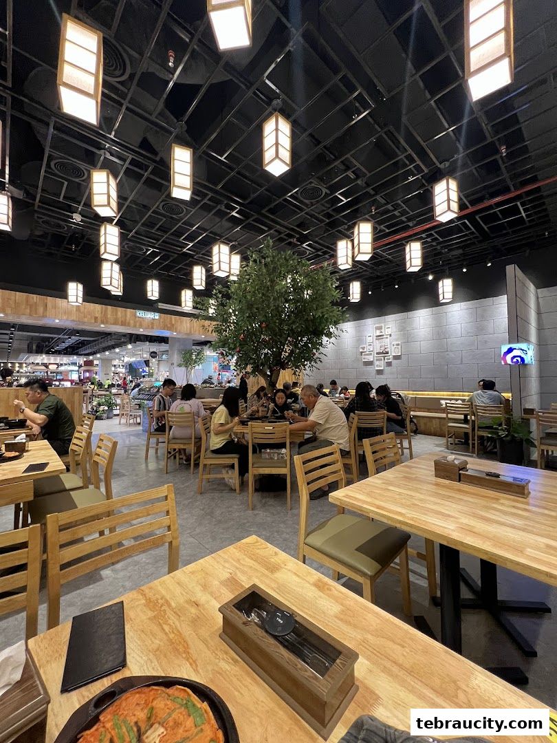 Interior view of a busy Korean restaurant with diners and modern lighting.