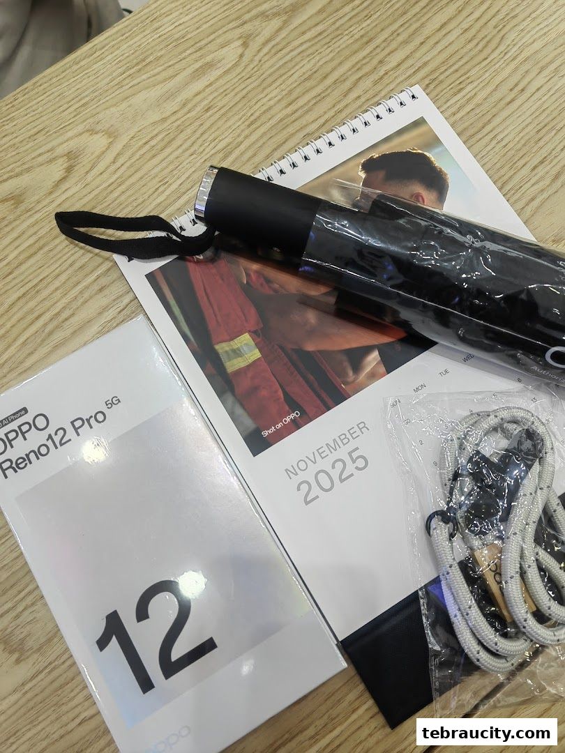 OPPO Reno12 Pro 5G box, umbrella, and lanyard on a wooden surface.