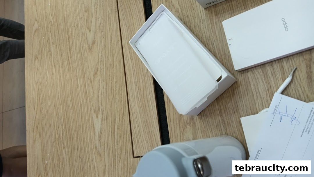 OPPO phone box and accessories laid out on a wooden surface.