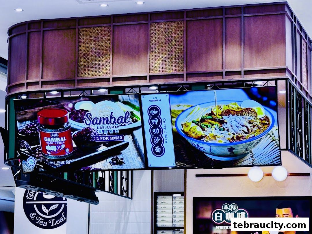 Digital menu boards displaying Nasi Lemak, Curry Laksa, and White Coffee at Oriental Kopi.