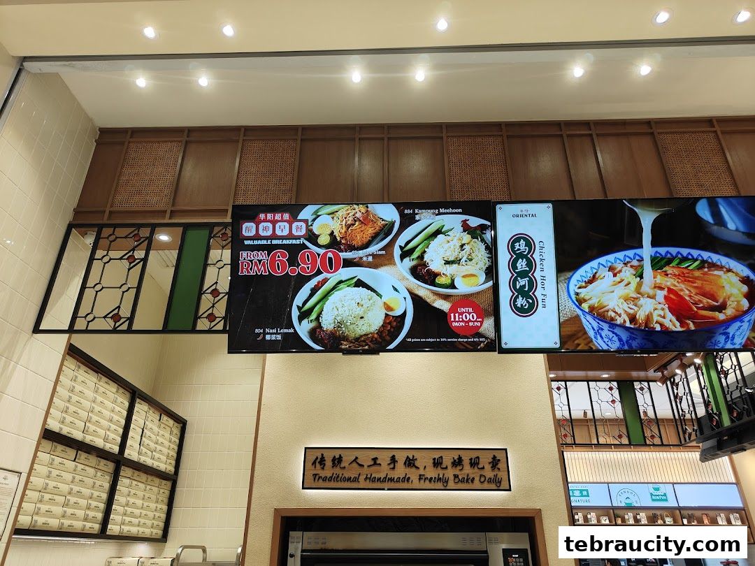 Digital menu board displaying breakfast deals and dishes like Nasi Lemak and Chicken Hor Fun.