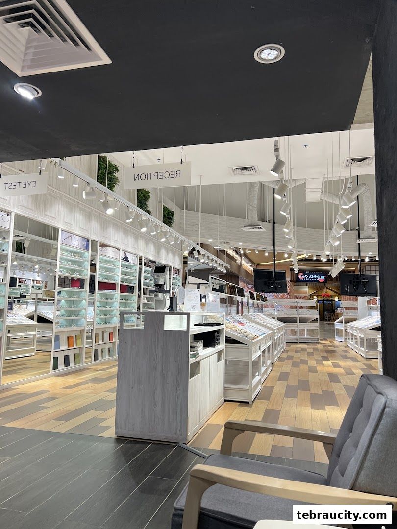 Interior view of an optical shop with display shelves filled with glasses and a reception area.
