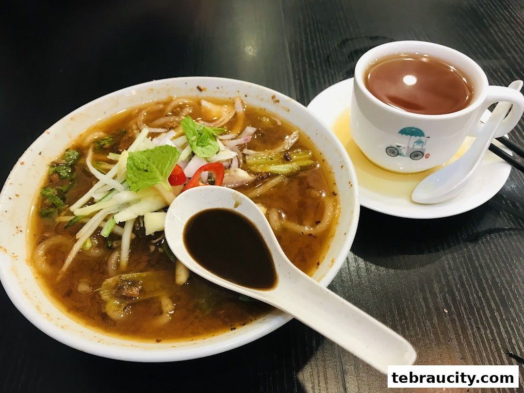 A bowl of Penang Road Teochew Chendul with a cup of tea and a spoon.