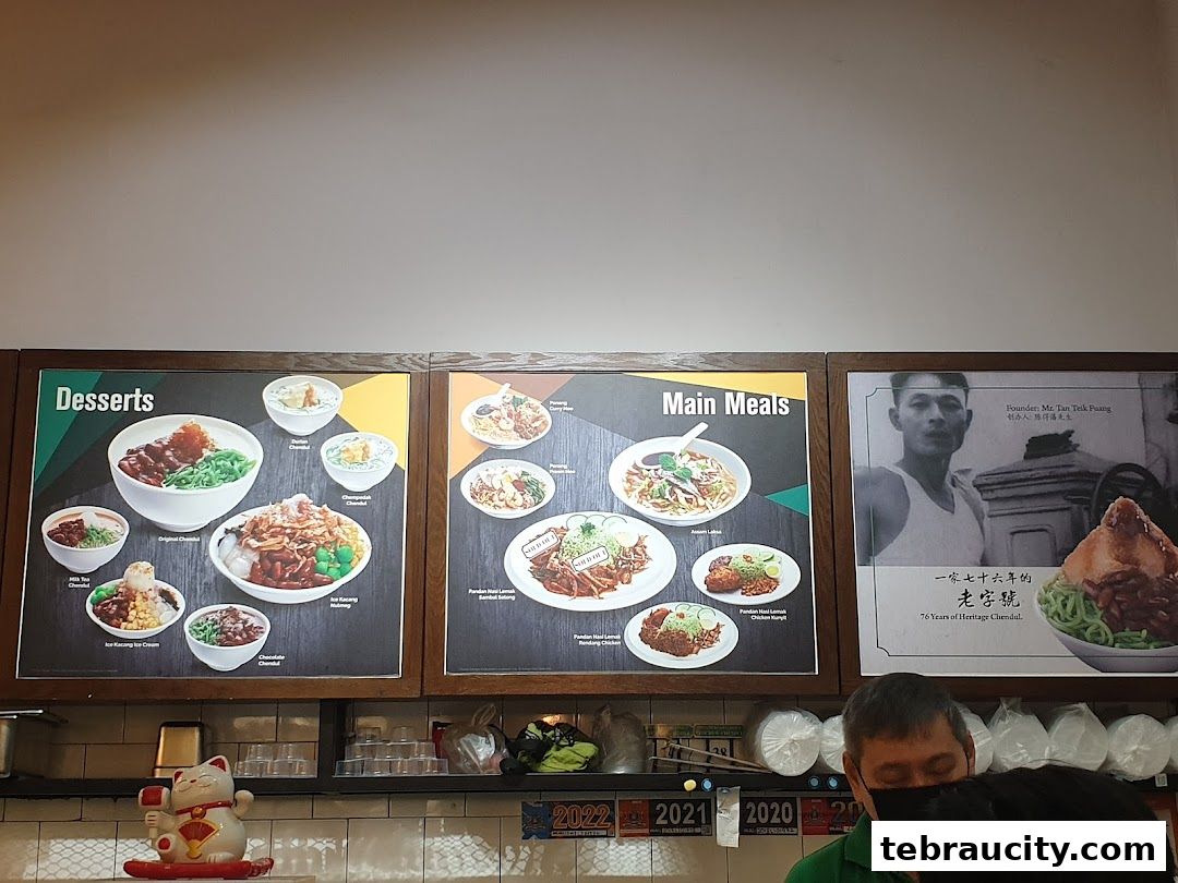 A menu board displaying desserts and main meals, with a historical photo of the founder.