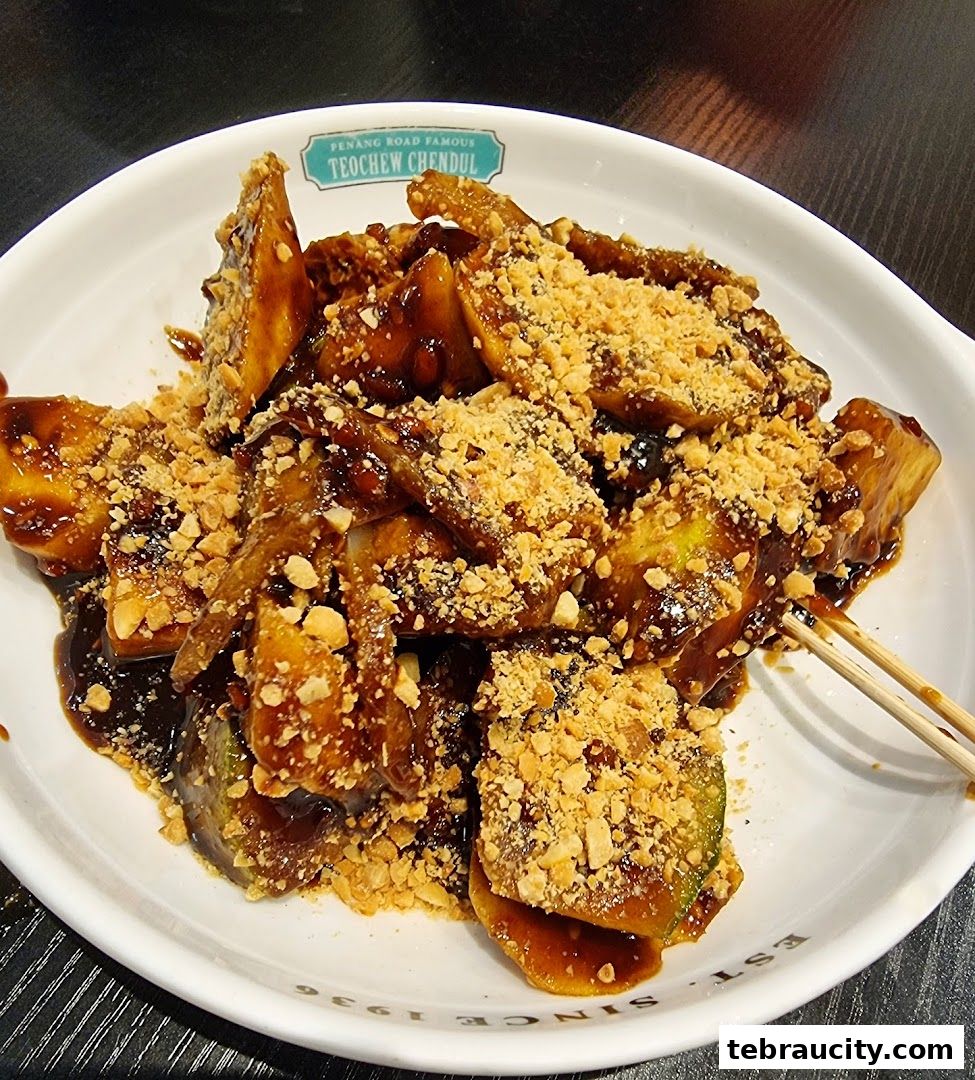 A close-up of a white bowl filled with a dessert topped with sauce and crushed peanuts.