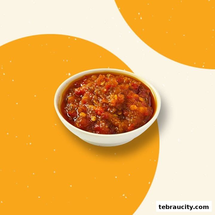 A bowl of spicy sambal chili sauce with visible chili flakes.