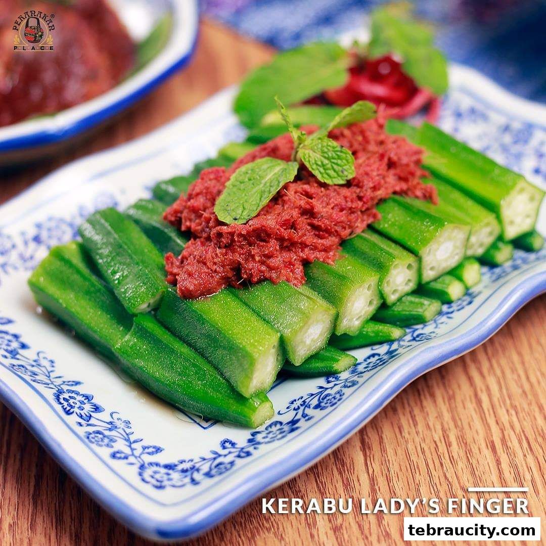 A plate of Kerabu Lady's Finger with a dollop of sambal and mint leaves.
