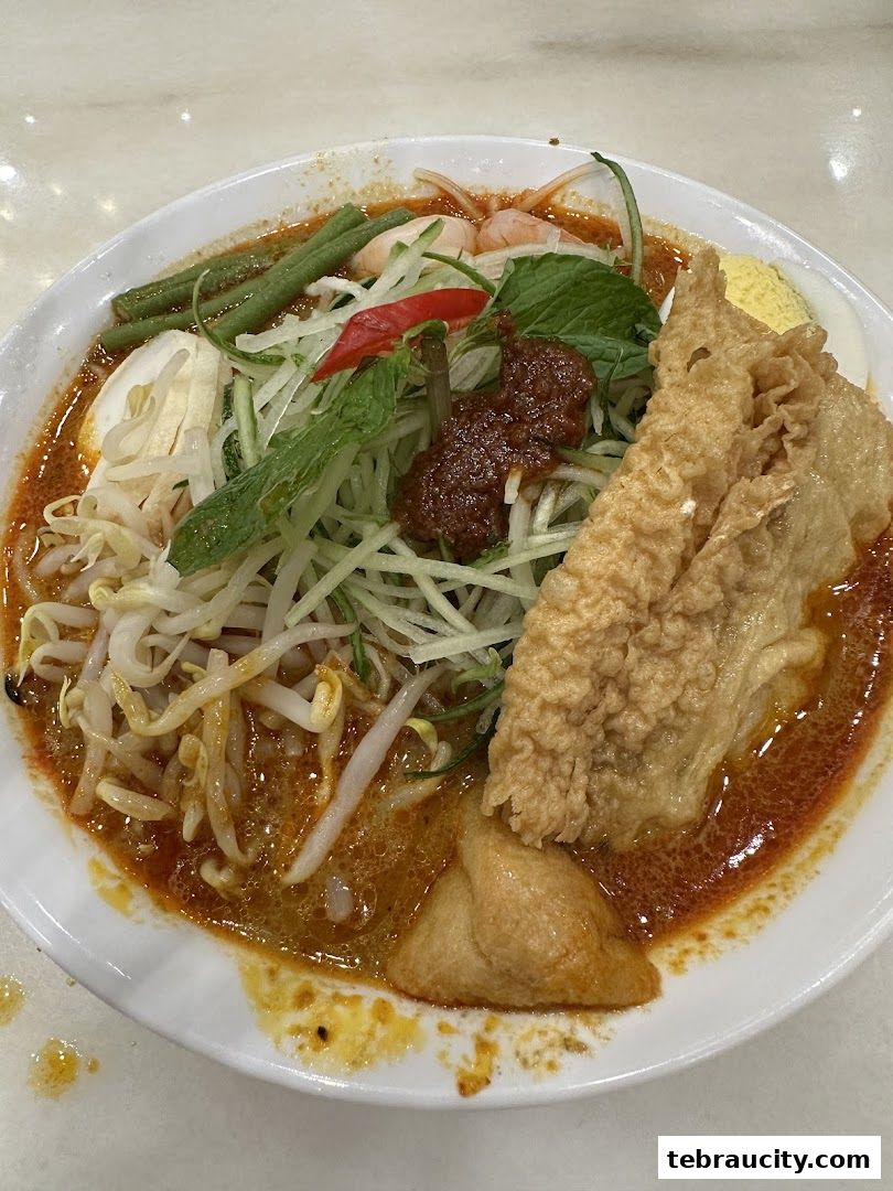 A close-up shot of a delicious bowl of Laksa with various toppings and a rich broth.