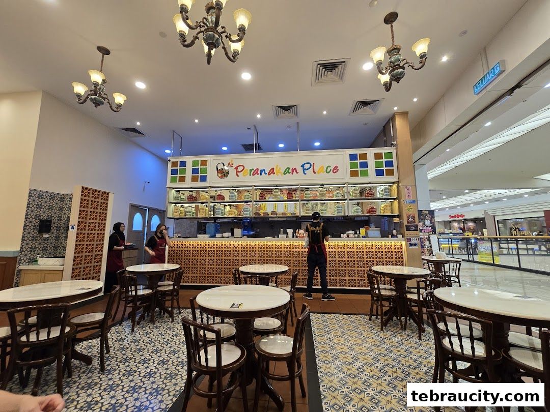 Interior of Peranakan Place restaurant with tables, chairs, and a counter.
