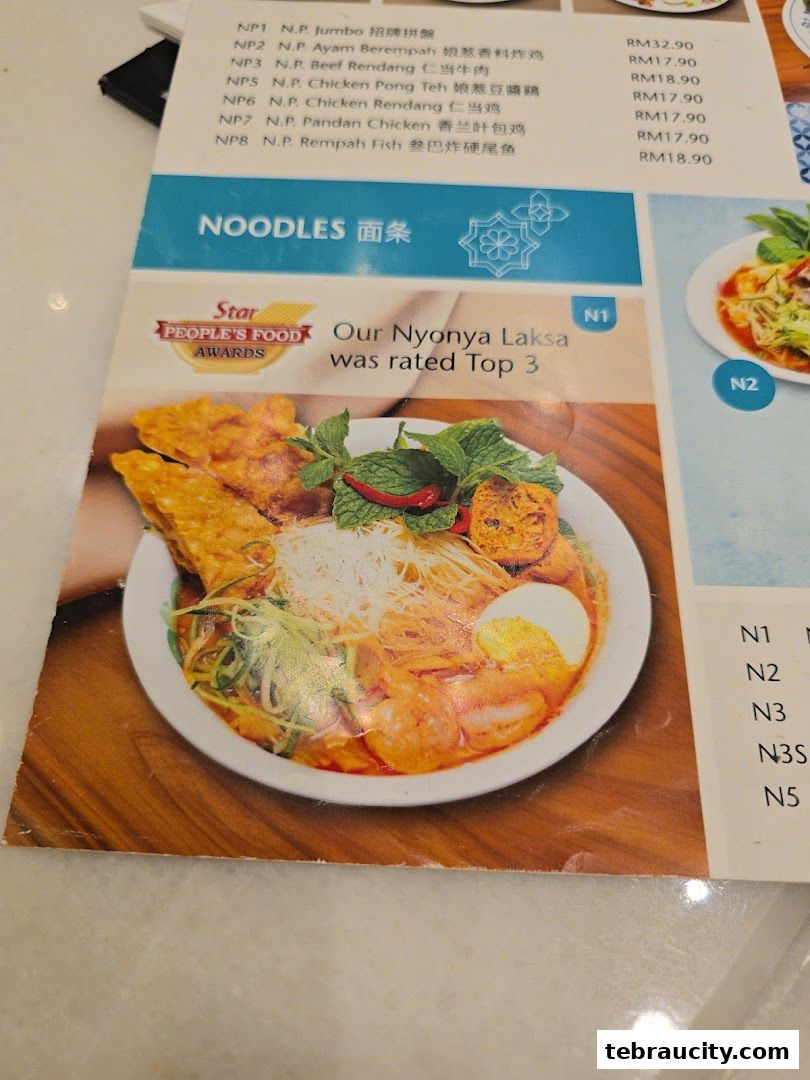 A menu page showcasing Peranakan dishes, including noodles and a highly-rated Nyonya Laksa.
