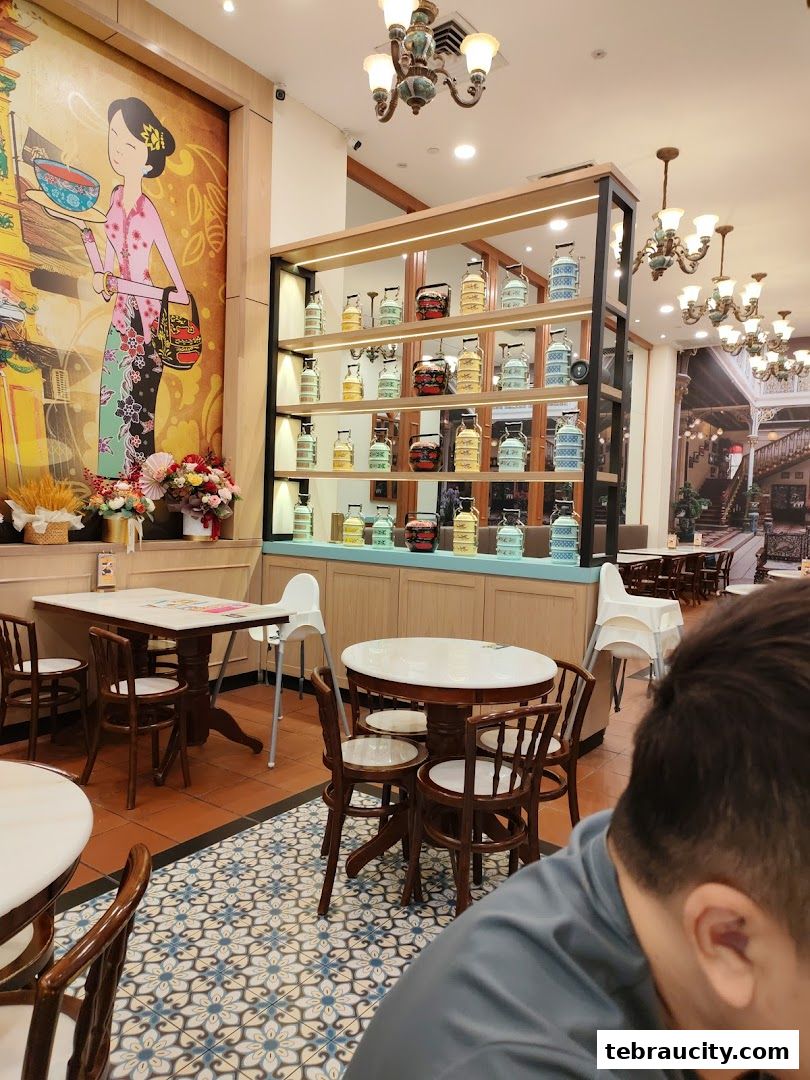 Interior of a Peranakan-themed restaurant with traditional decor and seating.