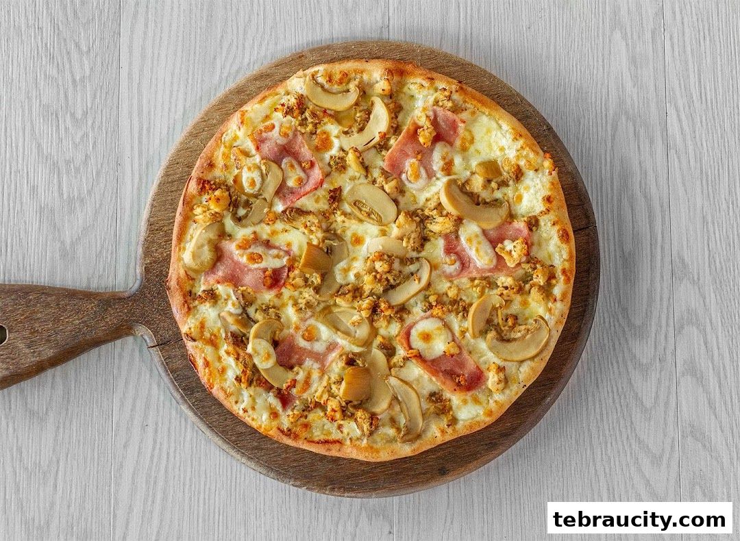 A delicious pizza topped with mushrooms and ham on a wooden board.