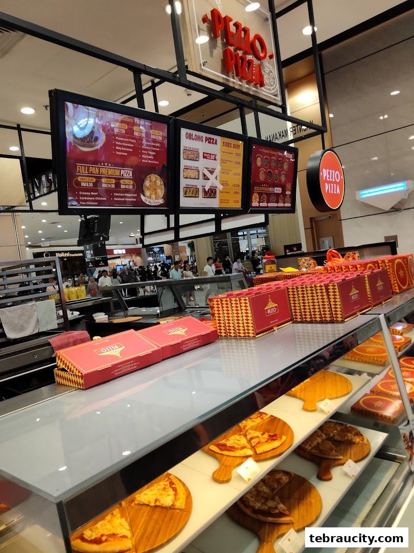 A display of pizzas and pizza boxes at a Pezzo Pizza shop.