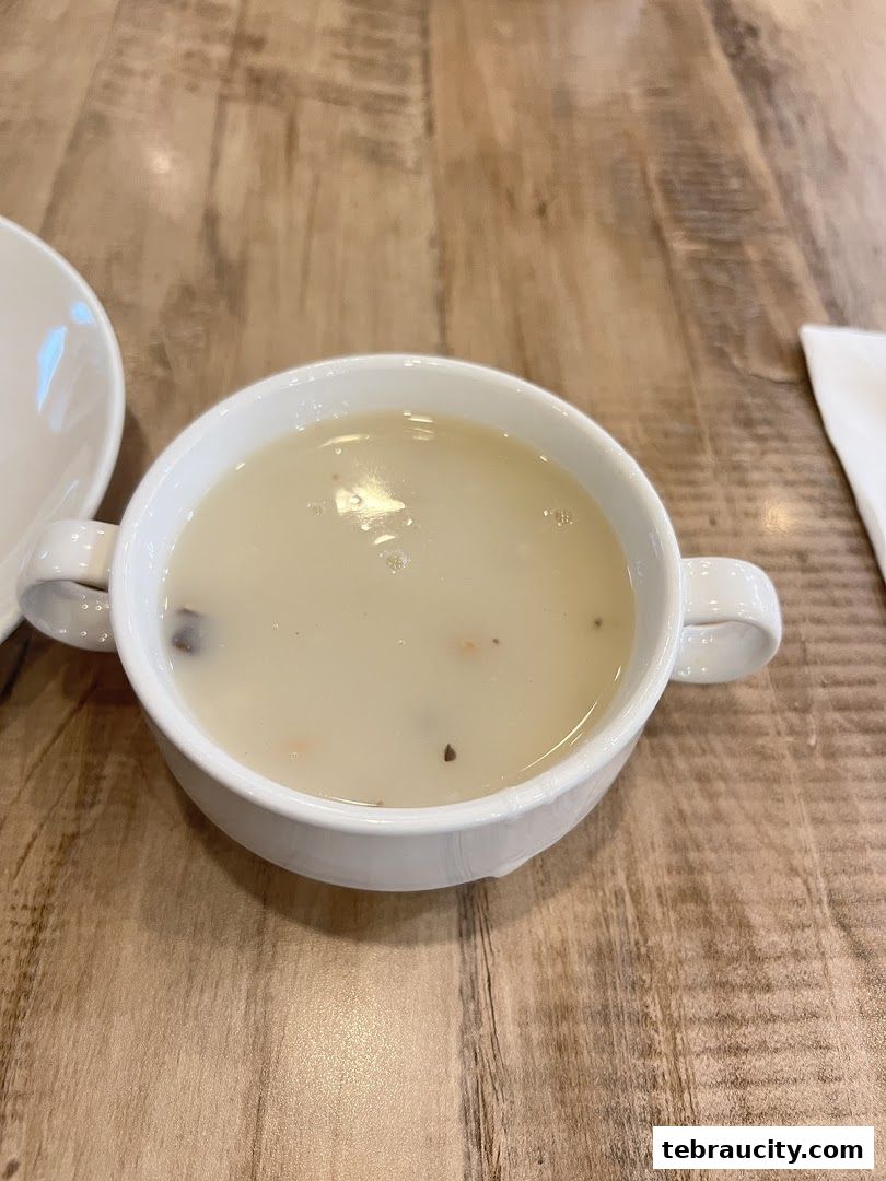 A close-up shot of a bowl of creamy mushroom soup on a wooden table.
