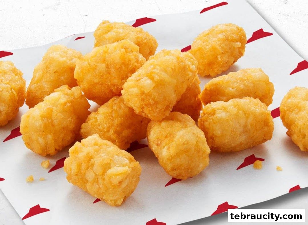 A pile of golden-brown potato tots served on Pizza Hut branded paper.