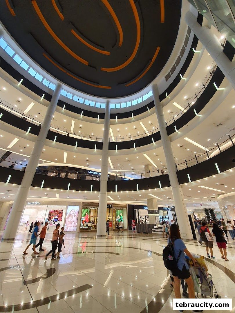 Interior view of a modern shopping mall atrium with multiple levels and shops.