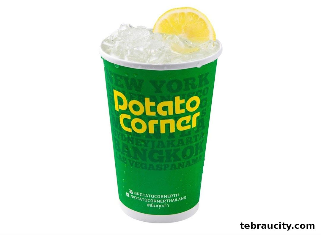 A refreshing drink from Potato Corner, served in a green cup with ice and a lemon slice.