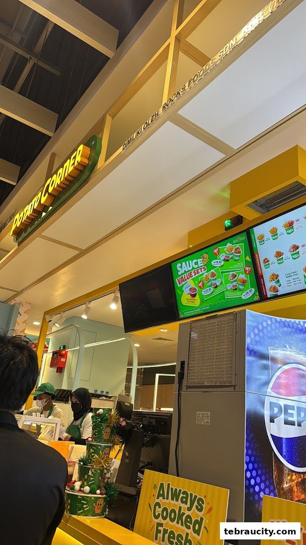 Potato Corner shop interior with staff serving customers and a menu display.
