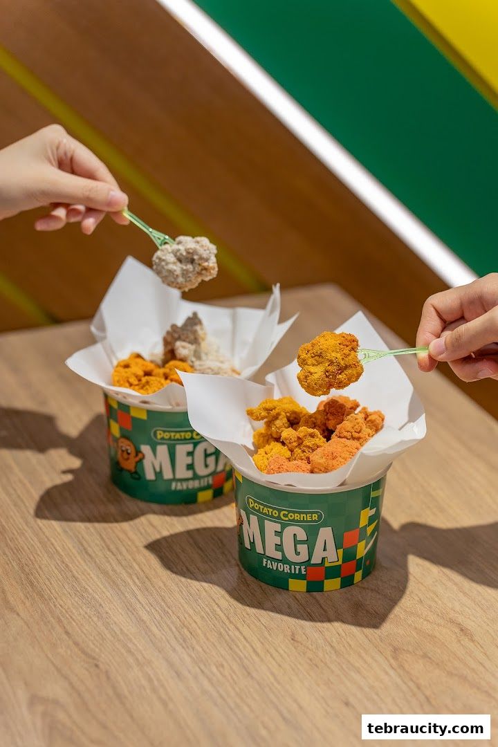 Two buckets of Potato Corner's Mega Favorite flavored fries are shown, with hands picking them up.