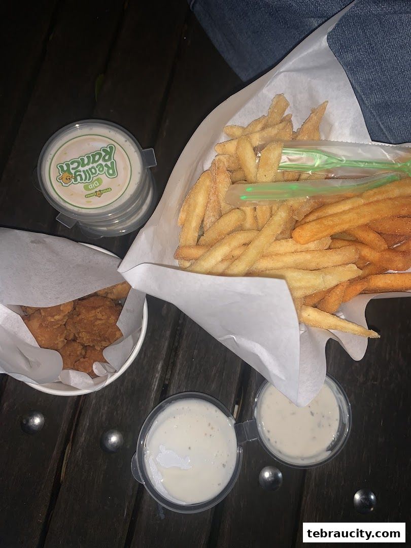 A close-up of Potato Corner fries and chicken bites with dipping sauces.