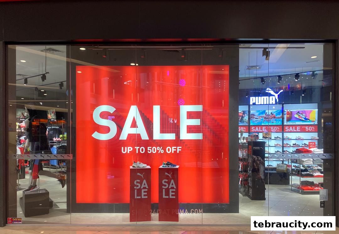 Puma store window display featuring a large 'SALE UP TO 50% OFF' sign and shoes.