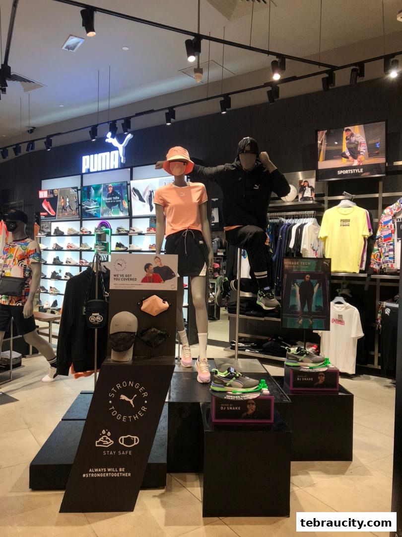Puma store interior with mannequins showcasing apparel and footwear, including DJ Snake collaboration.