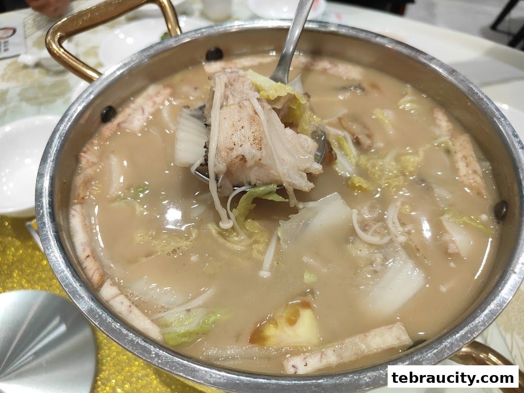 A close-up shot of a steaming hot pot filled with various ingredients and broth.
