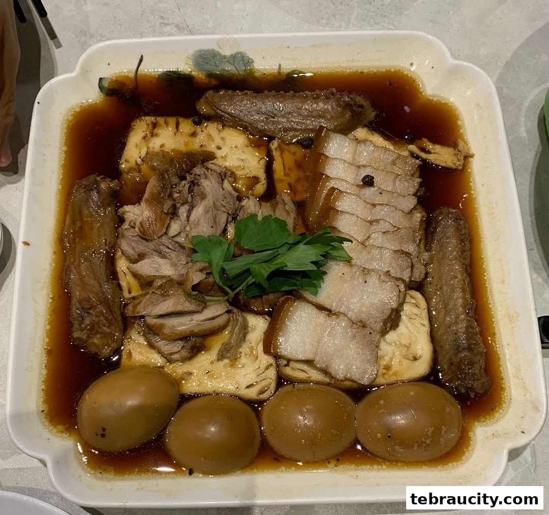 A platter of braised duck, pork belly, tofu, and eggs in a savory sauce.