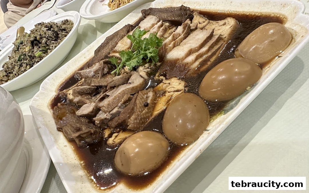 A platter of braised meats and eggs in a savory sauce, with a side of fried rice.