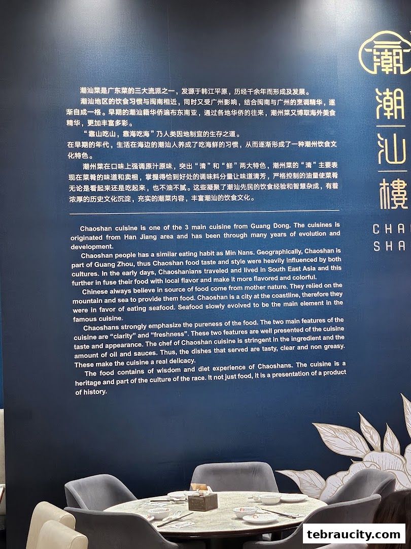 A wall with text describing Chaoshan cuisine and a round dining table with chairs.