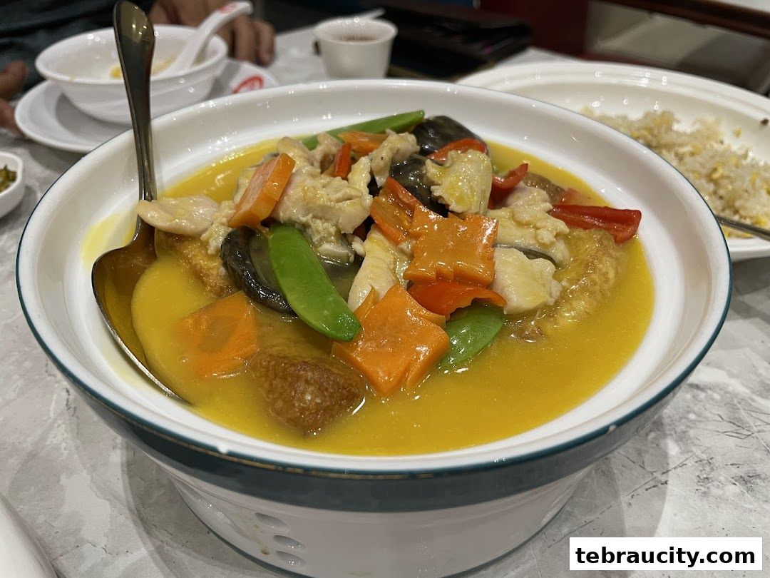 A close-up of a delicious dish with chicken, vegetables, and sauce, served in a white bowl.
