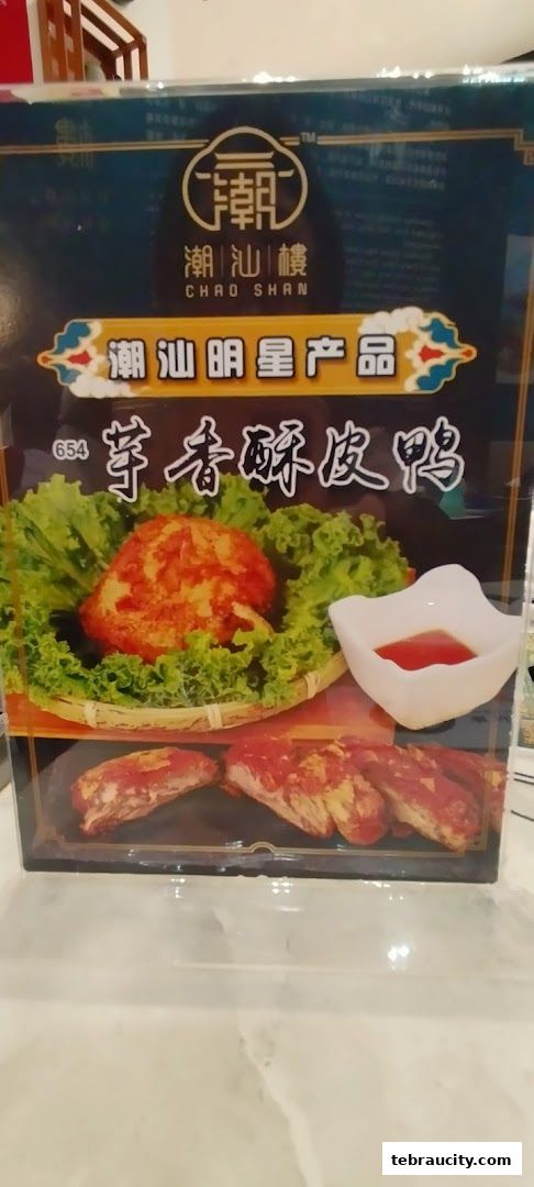 A menu item featuring crispy roasted duck with a side of dipping sauce.