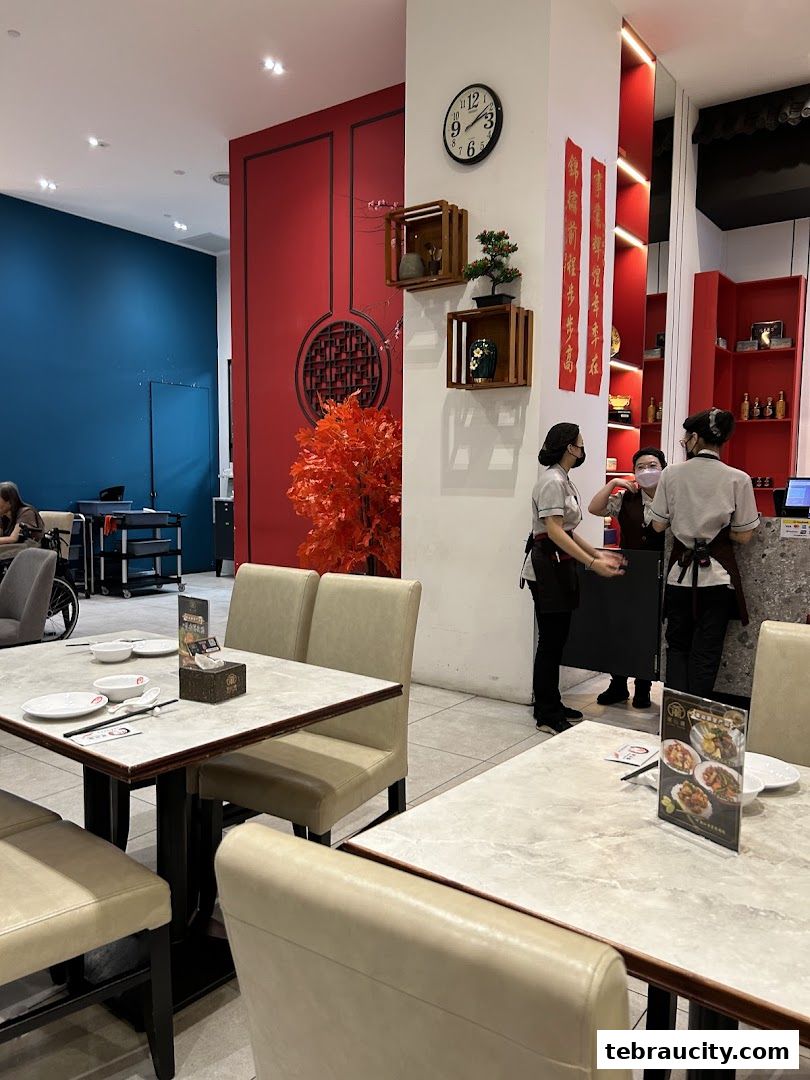 Interior of a restaurant with tables set and staff attending to customers.