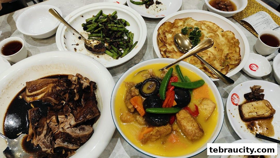 A table laden with various delicious Chinese dishes, including braised duck, stir-fried beans, and a savory soup.