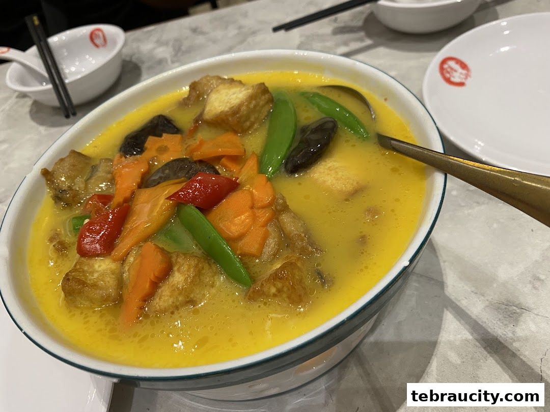 A close-up of a delicious bowl of soup with tofu, vegetables, and mushrooms.