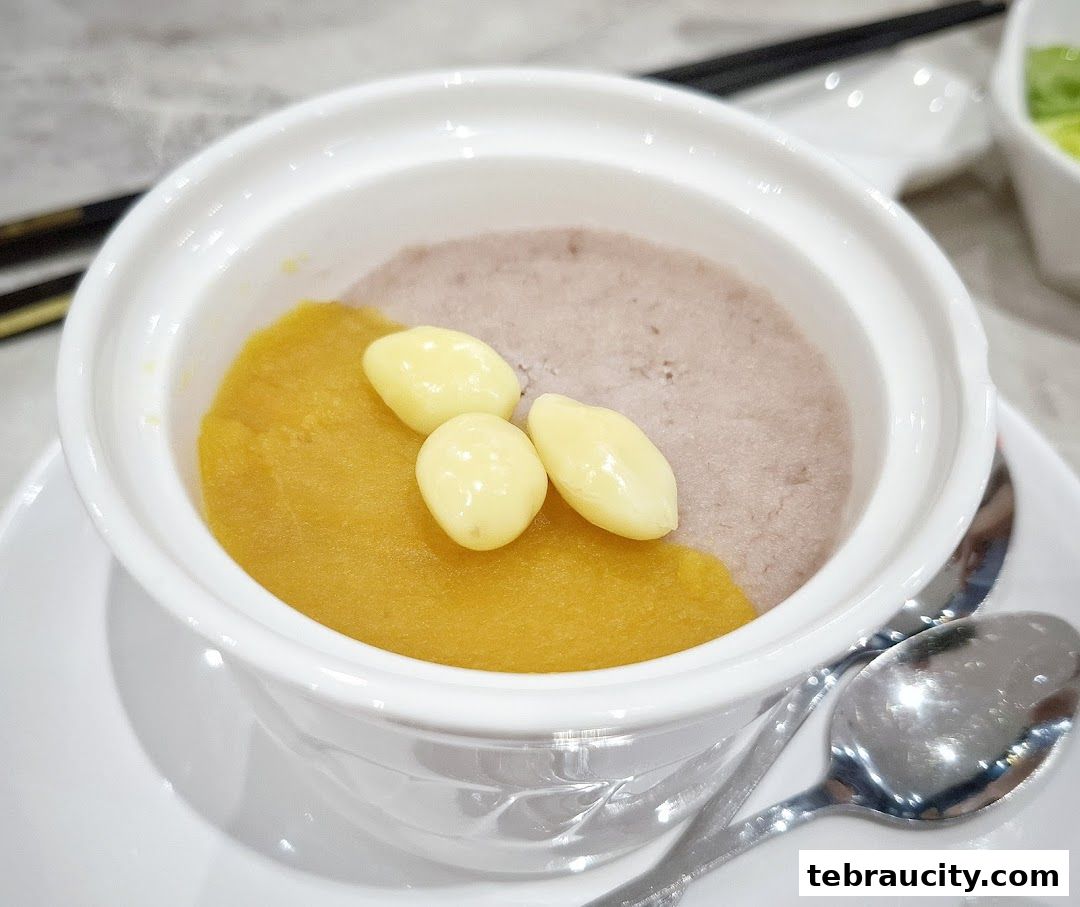 A close-up of a white bowl filled with a two-toned dessert, topped with ginkgo nuts.