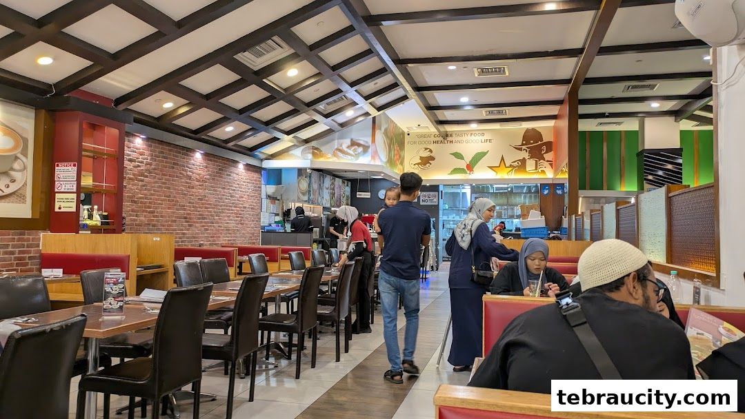 Interior view of a busy restaurant with diners seated at tables and staff working.