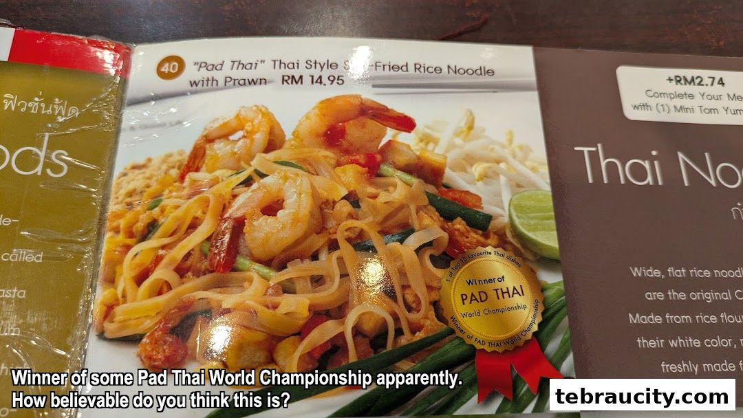 A close-up of a Pad Thai dish with prawns, advertised as a World Championship winner.