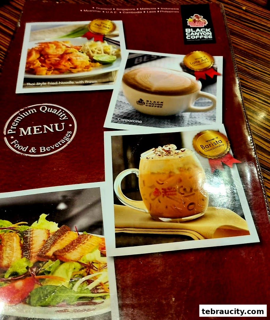 A menu from Black Canyon Coffee featuring Pad Thai, Cappuccino, and a salmon salad.