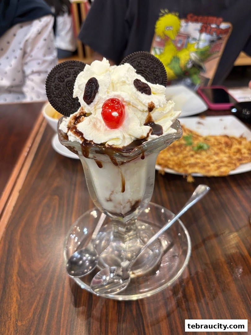 A delightful ice cream sundae decorated to look like a panda, served in a glass dish.