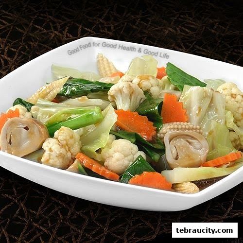 A white bowl filled with a colorful mix of stir-fried vegetables, including cauliflower, carrots, and cabbage.