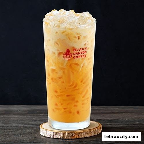 A tall glass of iced Thai milk tea with creamy layers, branded with Black Canyon Coffee.